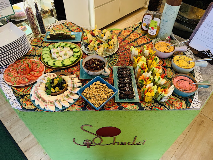 Colorful Schadzi plant-based catering table with salads, dips, and fresh vegetables